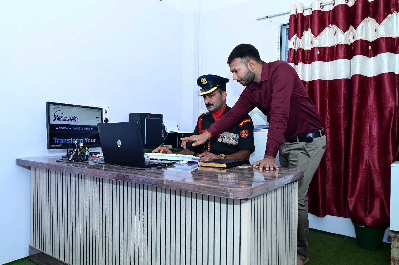 Student working on laptop in a tech workshop environment